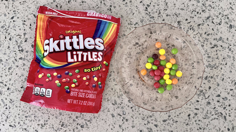 Skittles Littles package with candies on plate