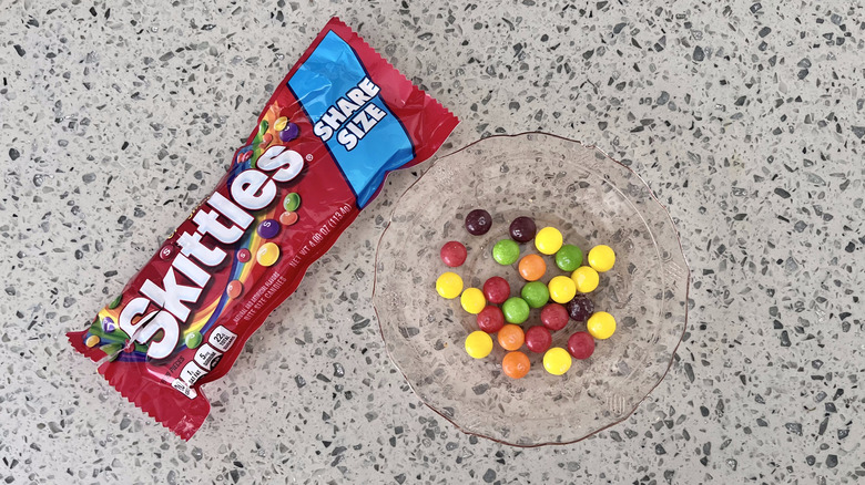 Bag of Skittles and candies on a plate