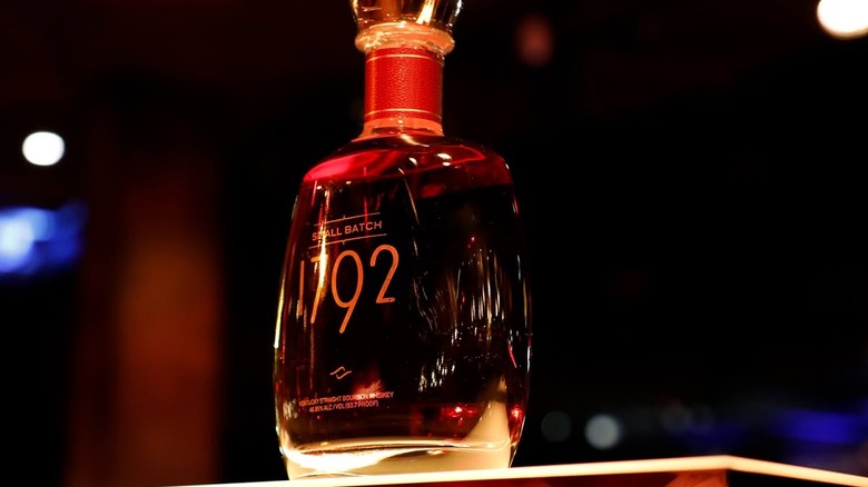A bottle of 1792 Small Batch bourbon posed on top of a lit stand