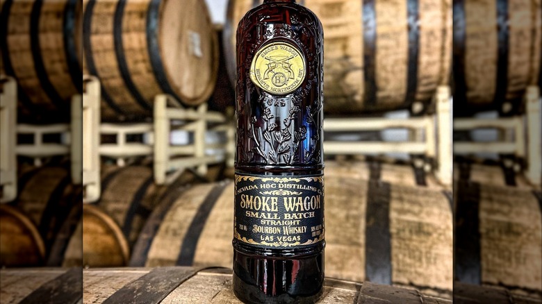 A bottle of Smoke Wagon Small Batch placed on a barrel, with further barrels stacked in the background