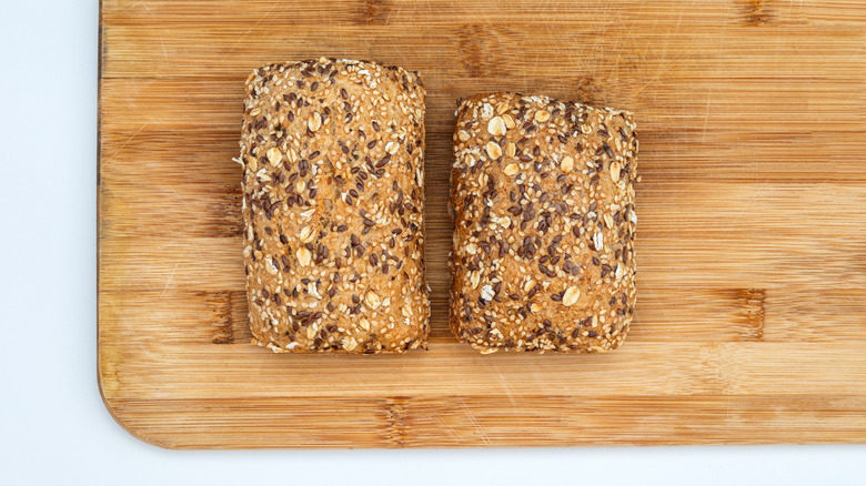 Two different sized bread rolls on a wooden cutting board