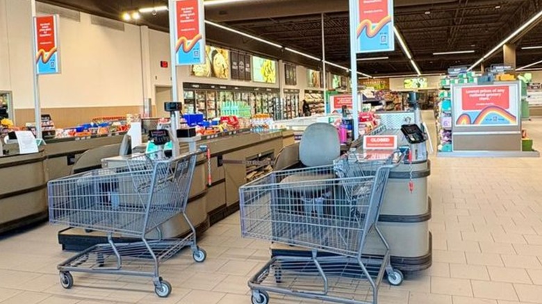 Aldi cash registers and shopping carts with upright freezers in the background