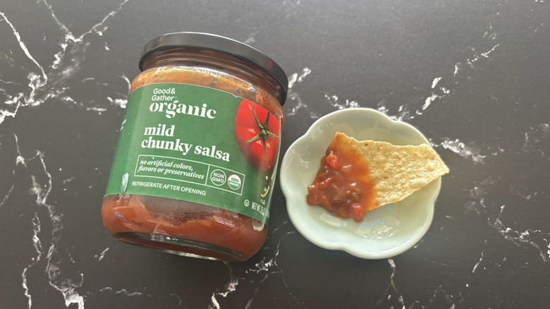 Target Good & Gather mild salsa jar next to chip with salsa on plate