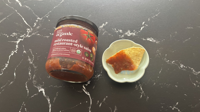 Target Good & Gather jarred salsa next to chip with salsa on plate