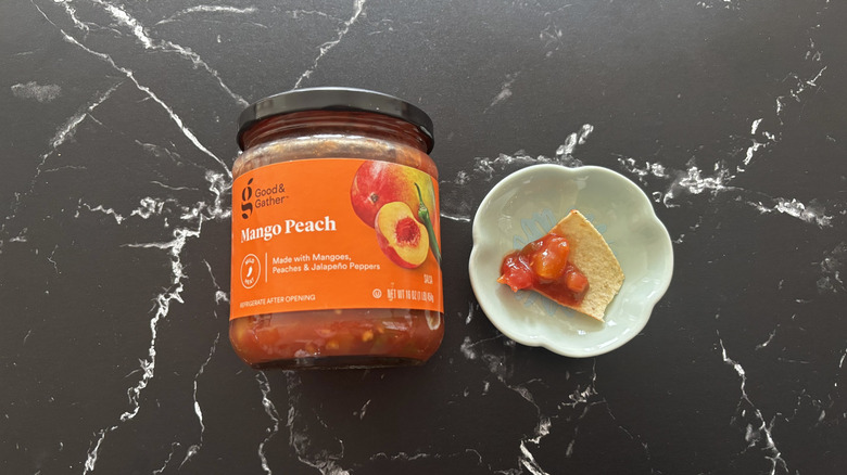 Target Good & Gather mango peach salsa jar next to chip with salsa on plate