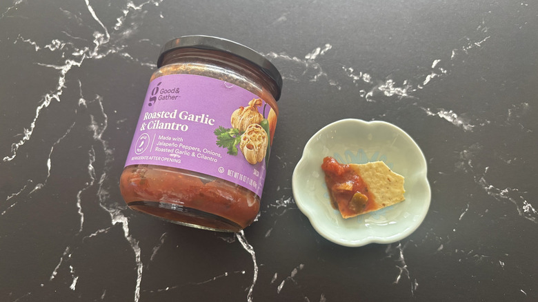 Target Good & Gather jarred salsa next to chip with salsa on plate