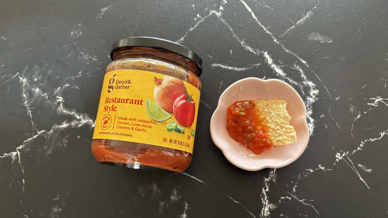 Target Good & Gather medium salsa jar next to chip with salsa on plate