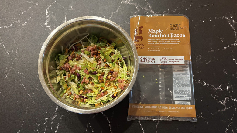 Maple bacon bourbon salad in bowl next to salad bag