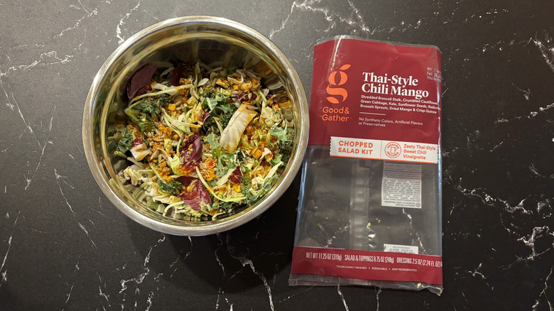 Thai-style salad in bowl next to salad bag