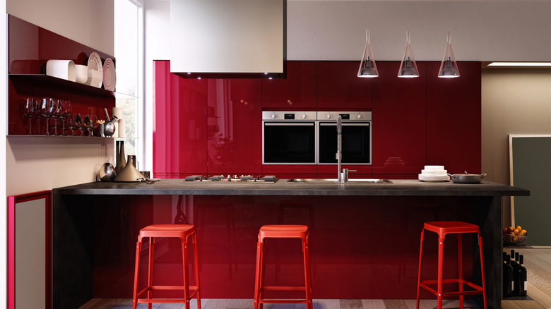 A modern kitchen with deep cherry red cabinets