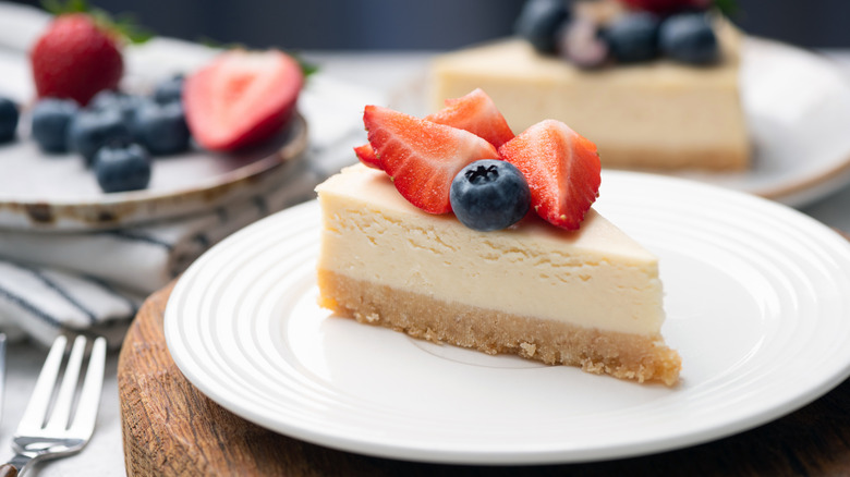 A slice of white cheesecake topped with berries