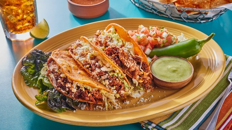 A plate of tacos and tomatoes