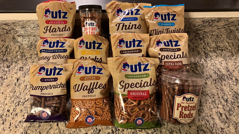 12 flavors of Utz pretzels are lined up in two rows of four on a countertop