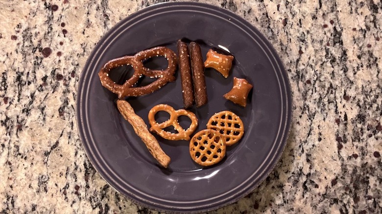 A purple plate fill with various Utz pretzels sits on a countertop