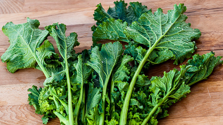 bunch of turnip greens on wooden bench
