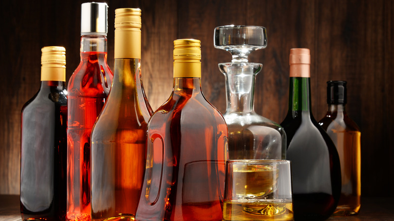A wide selection un unbranded bottles seemingly containing dark spirits