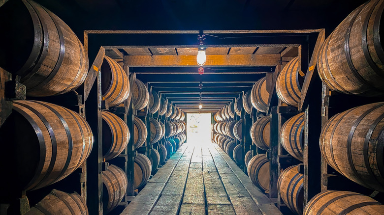 whiskey barrels in storage with rows of barrels on each side