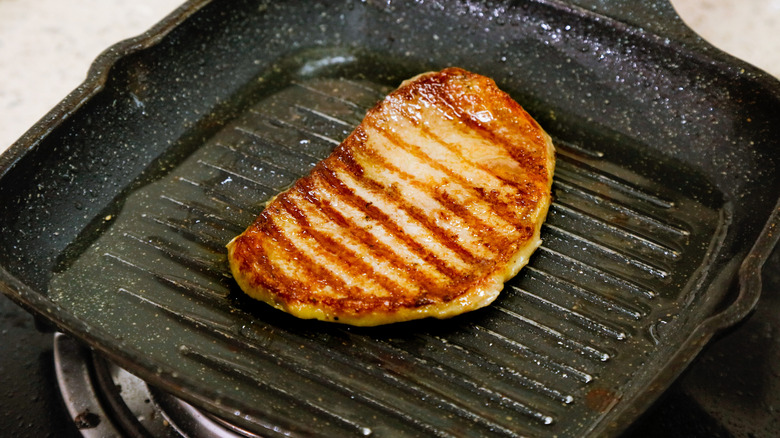 A flattened chicken breast, deeply seared in a heavy cast-iron grilling pan