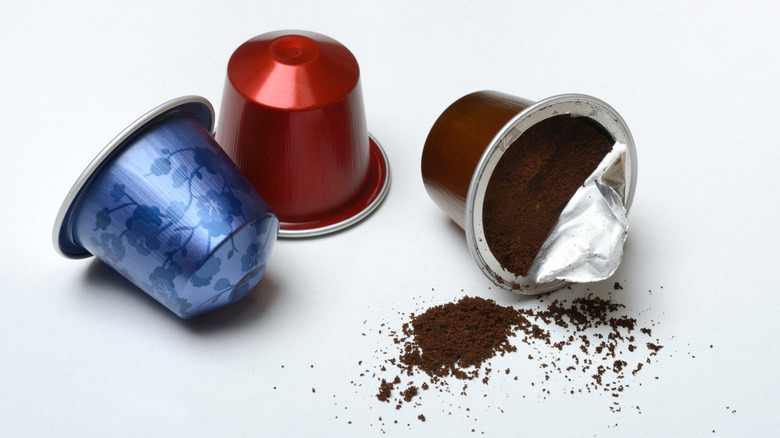 Three single use coffee pods on white background
