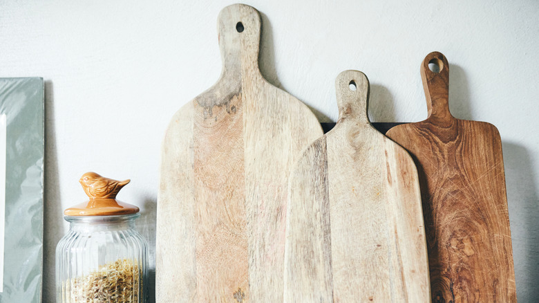 Wooden cutting board propped up against wall in kitchen
