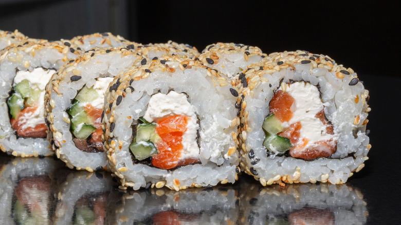 Smoked salmon and cream cheese sushi rolls coated with sesame seeds