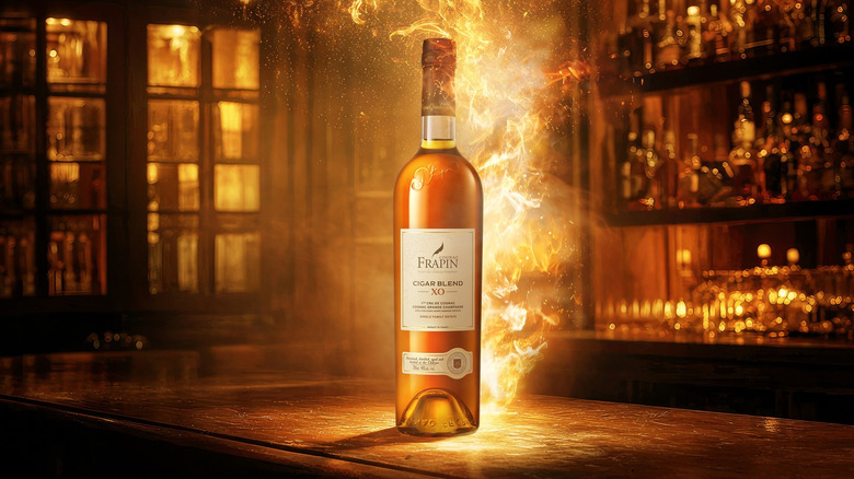 A stylized shot of a bottle of Frapin Cigar Blend XO on a bar with computer generated flames emerging from it