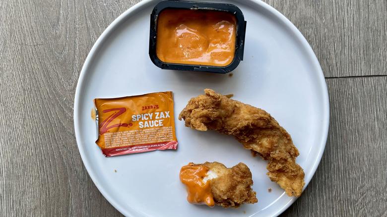 Chicken finger pieces with spicy Zax sauce on a plate