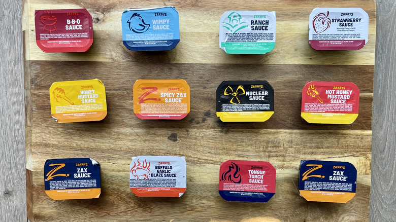 Assorted Zaxby Dipping sauces on a wooden cutting  board