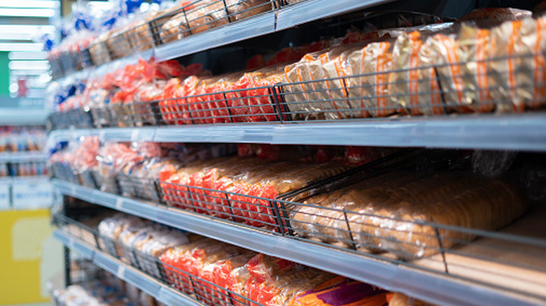 Loaves of bread arranged on the racks of a grocery store display