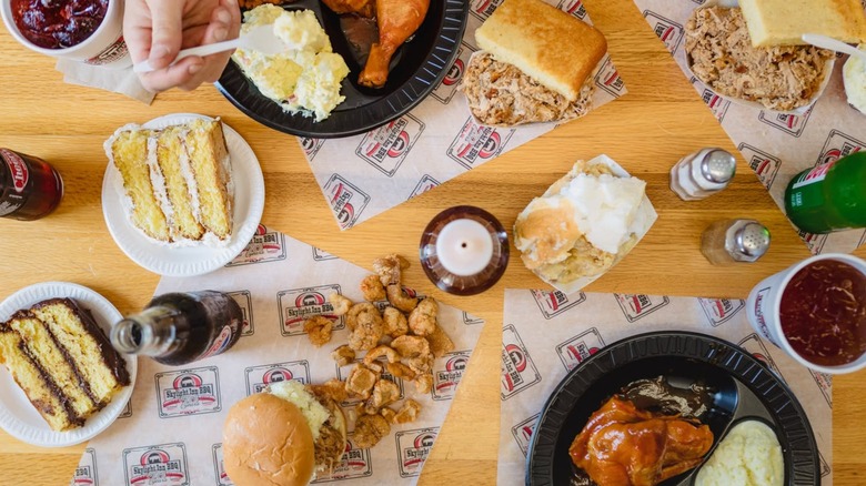 Assortment of BBQ dishes, sides, and cake on table from above
