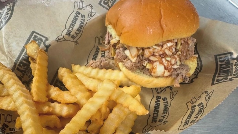 Pulled pork sandwich with slaw and fries on Stamey's paper