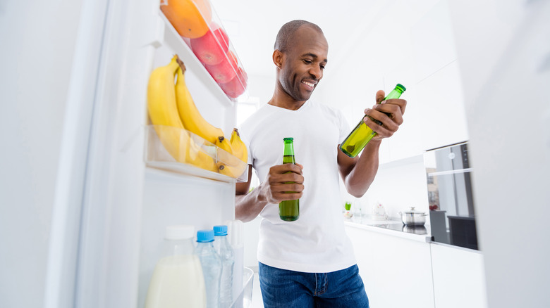 Man looking at beer from fridge
