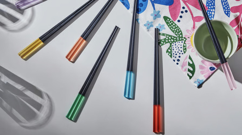 Six pairs of different colored chopsticks styled on a white table