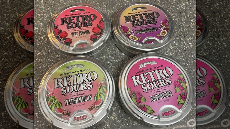 Four different flavored tins of Retro Sours candy