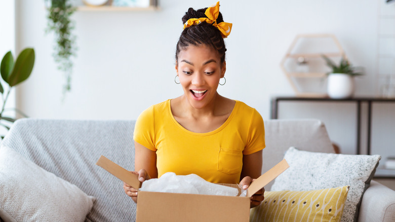 woman in yellow opening package