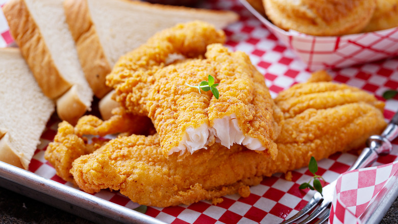 Fried catfish with bread on checkered paper
