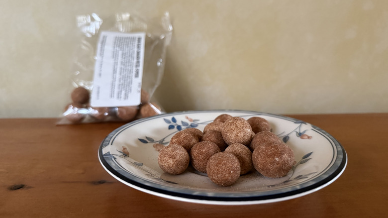 Brown sugar cinnamon pretzel poppers on plate in front of bag