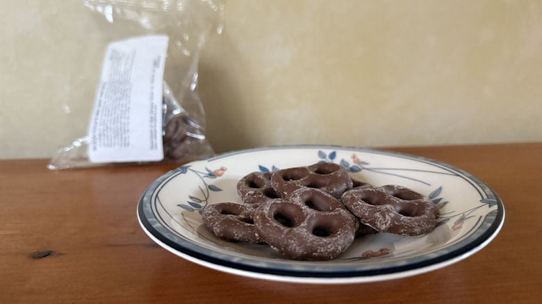 Milk chocolate mini twist pretzels on plate in front of bag