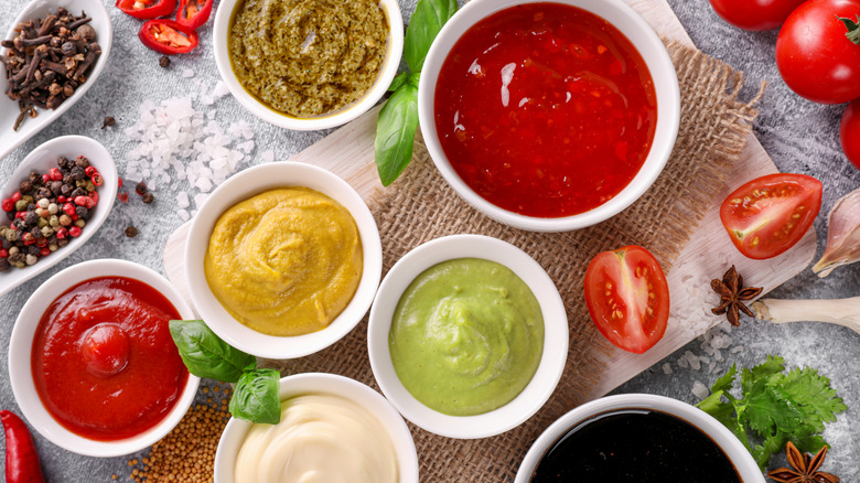 White cups of condiments on a busy countertop