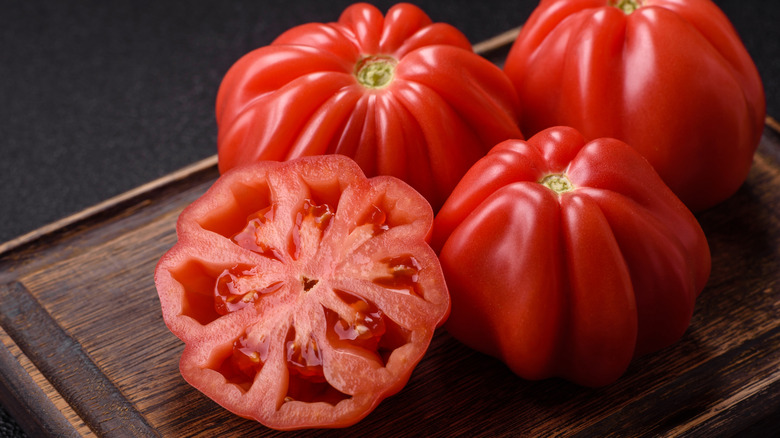 Heirloom tomatoes sliced on a wooden cutting board