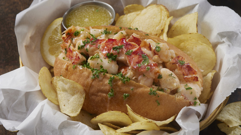 Buttered lobster roll on a tray with potato chips