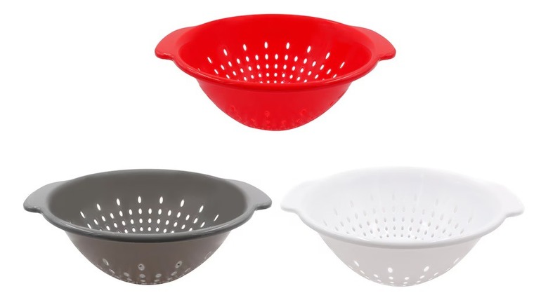 Three plastic colanders in red, black, and white colors