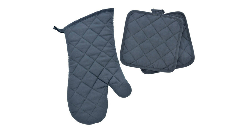 Dark grey oven mitt next to two dark grey pot holders