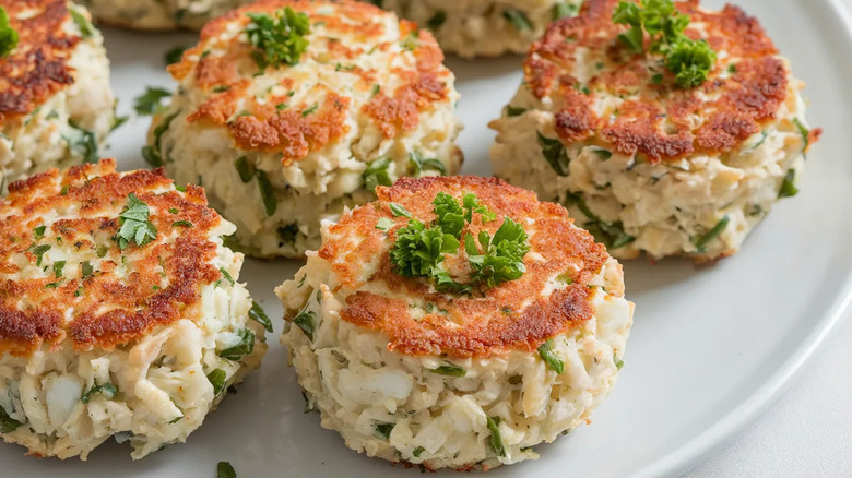 Crab cakes arranged on white plate
