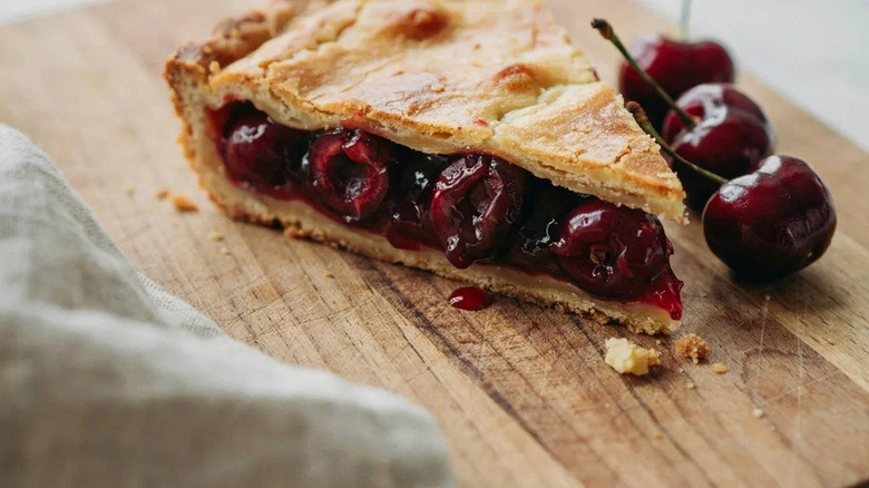 Slice of cherry pie on a cutting board along the west coast