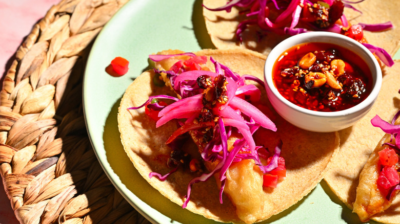 Fish tacos with pickled red onions on a natural fiber placemat on the west coast
