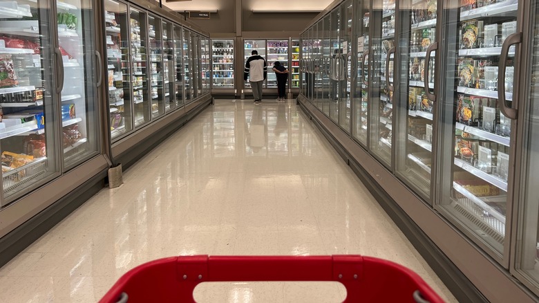 Shopping cart driving down Target frozen food aisle with people at the end