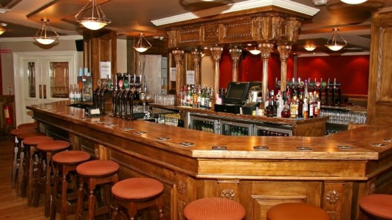 Curved wood bar with orange stools