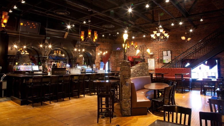 Bar with tables and booths with dark woodwork and brick
