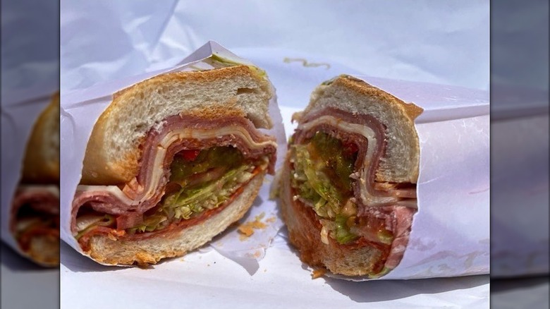 Italian sandwich cut in half on white paper